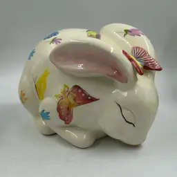 Pre-Owned White Ceramic Sleepy Bunny With Different Colored Butterfly’s.  Has Some Crazing.