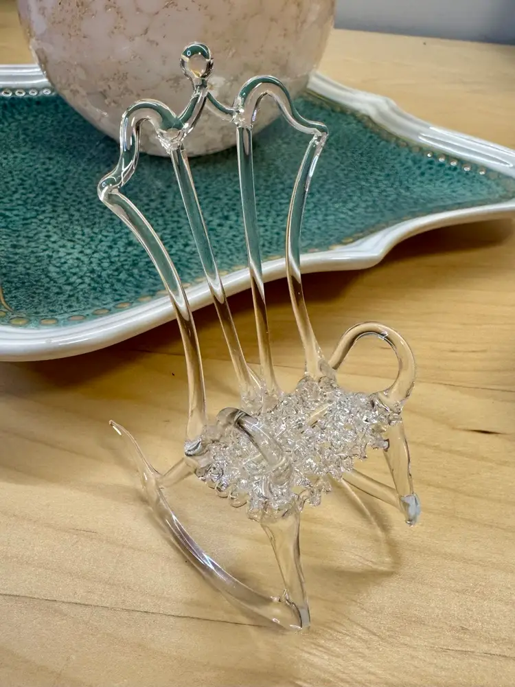 Mini vintage hand-blown glass rocking chair figurine. It is a delicate, decorative object, often used as a collectible