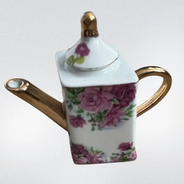 Vintage miniature porcelain teapot with pink roses and gold accents. 4” X2”