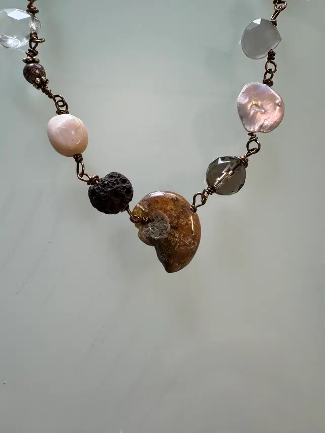#30 Fossil Of The Sea Necklace Centered On A  Brass Necklace And Surrounded And Wired With Multiple Shapes Colors Of Gemstones Pearl Abalone And Glass Crystals Lava stone.  17”