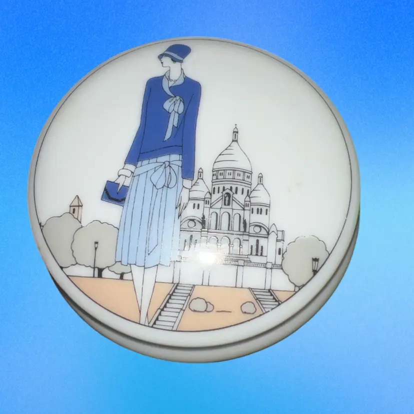 This is a vintage French porcelain trinket box featuring an Art Deco Paris transfer print By Jacque Lobjoy, Made In France 3”