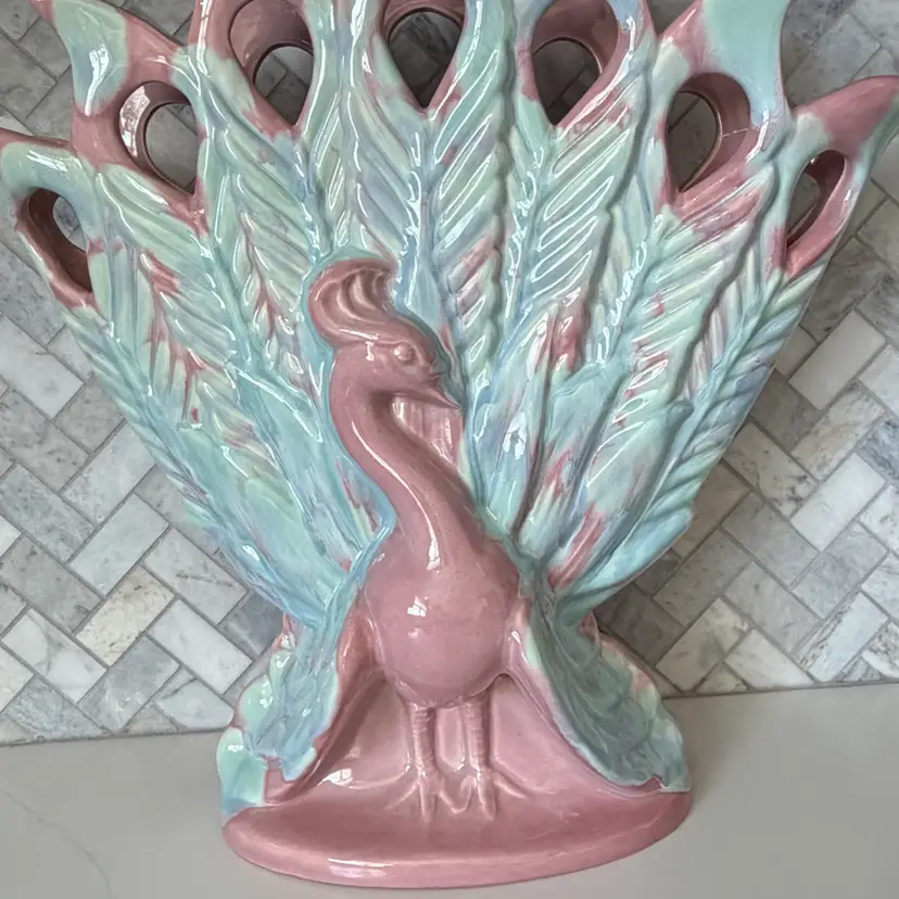 A vintage Royal Haeger ceramic peacock vase with a pink and blue glaze.