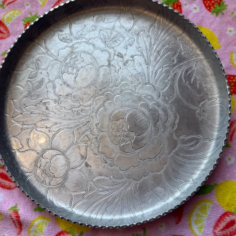 Vintage embossed aluminum serving tray with floral and leaf motifs.