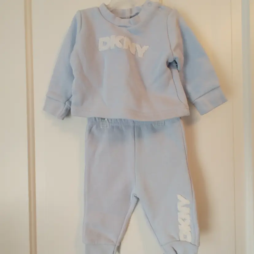Kids- Brand: DKNY. Size 3-6 months. 2 piece set. Blue sweat suit. Material: 72% cotton, 28% polyester. No callouts.