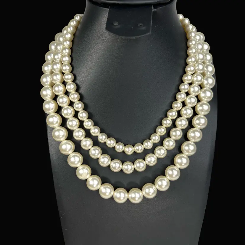 16” Luxurious Sheen Triple Strand Faux Pearl Necklace w Rhinestones In Clasp. Stamped JAPAN on Clasp. Silver-tone Metal.