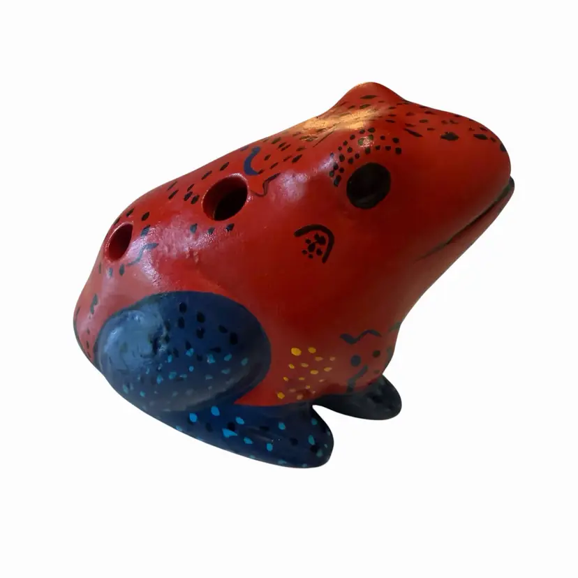 This is a hand-painted ceramic frog figurine, often functional as a small whistle or percussion instrument, typically found in artisan markets