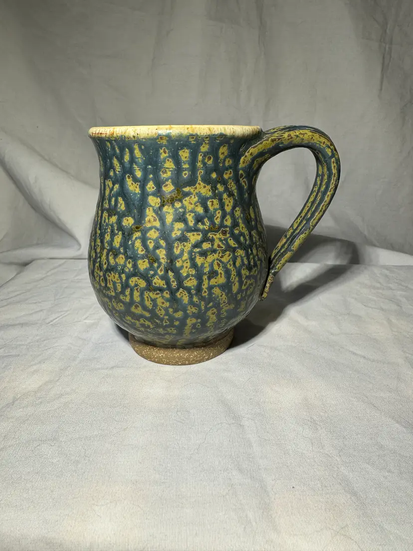 Studio pottery mug with a blue and yellow/green crawl glaze