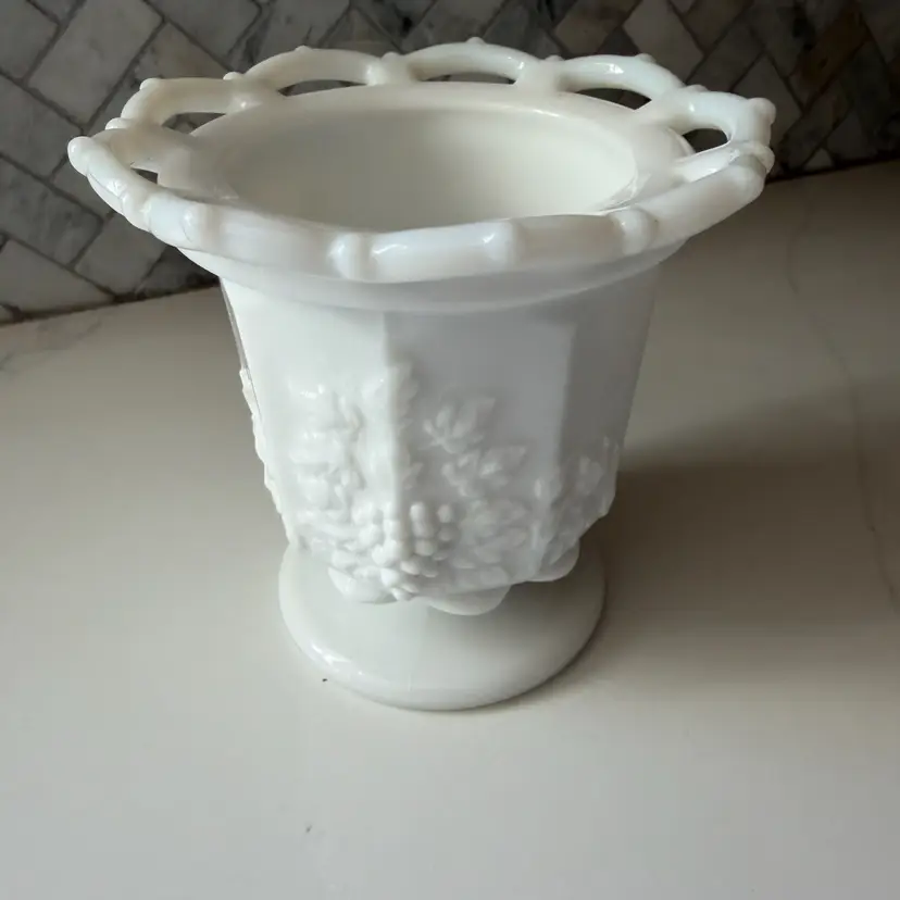 A Westmoreland milk glass footed spooner in the paneled grape pattern.