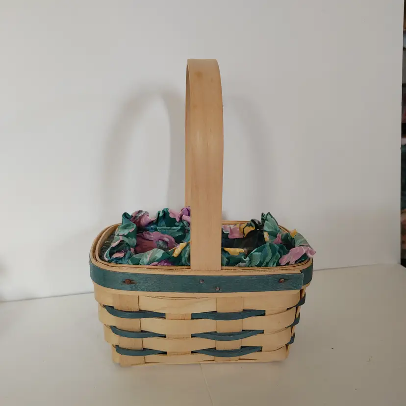 Longaberger basket- includes floral and plastic liners. Signed and dated 1992. 5.25w x 9h x 7d. Good condition.