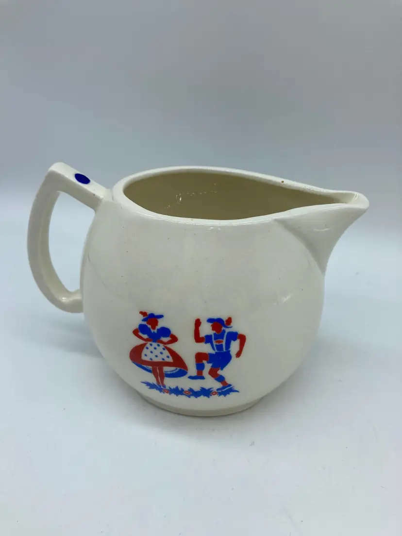 Porcelain pitcher made in Czechoslovakia. Features folk art Alpine dancers in red and blue on both sides.