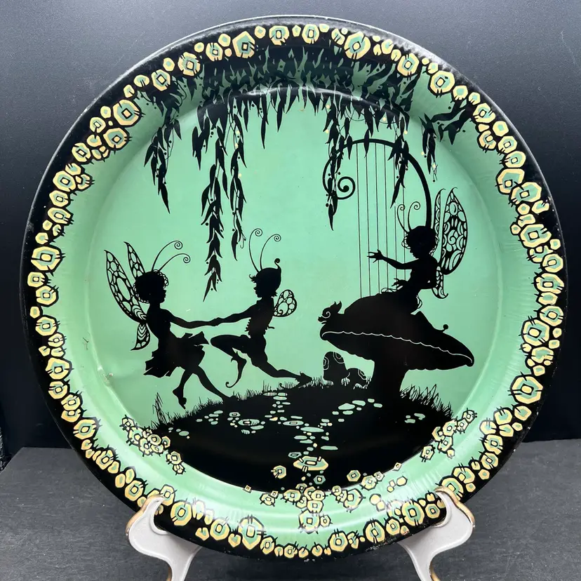 #166A Vintage Silhouette Of Dancing Fairies On A Turquoise Blue/Green Tin Tray/Dish
Would Be A Great Display Piece On An Easel Or As An Addition To A Gallery Wall 
Some Pitting Of The Metal In Spots And Wearing Around The Rim And There Is One Dent On The Left See Pictures.