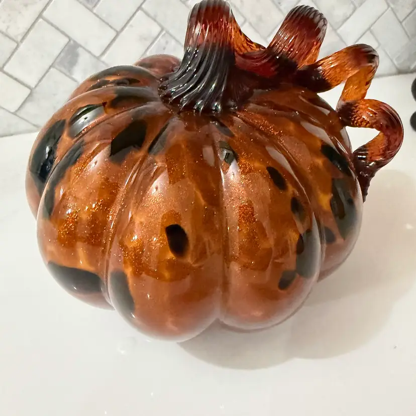 A blown art glass pumpkin with leopard print and glitter.