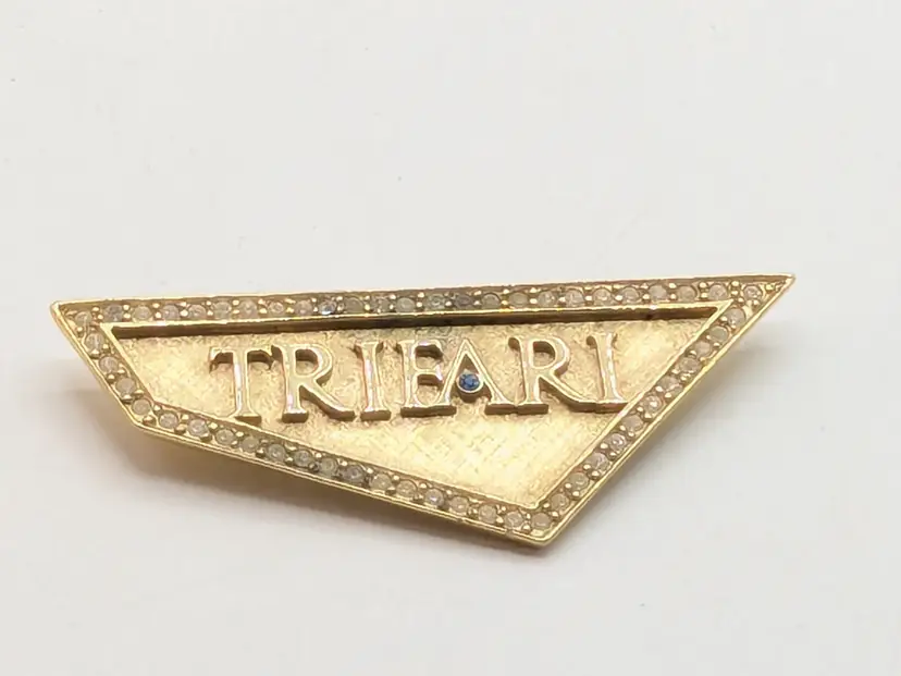 Vintage Trifari Gold Tone Corporate Logo Display Brooch with Blue Rhinestone