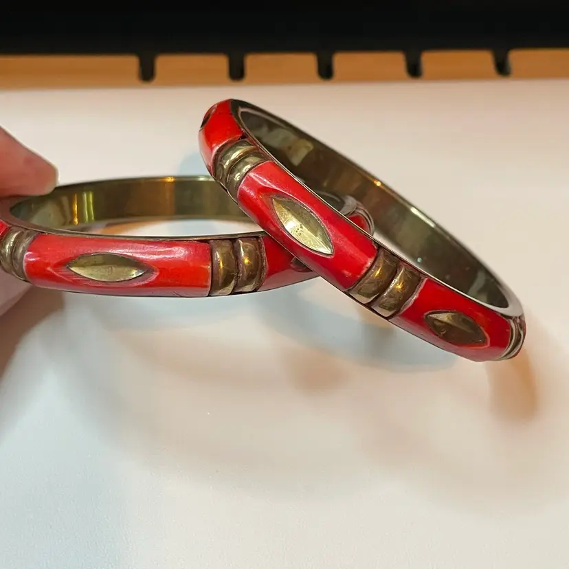 04 A pair of vintage brass bangles with red inlay and brass accents