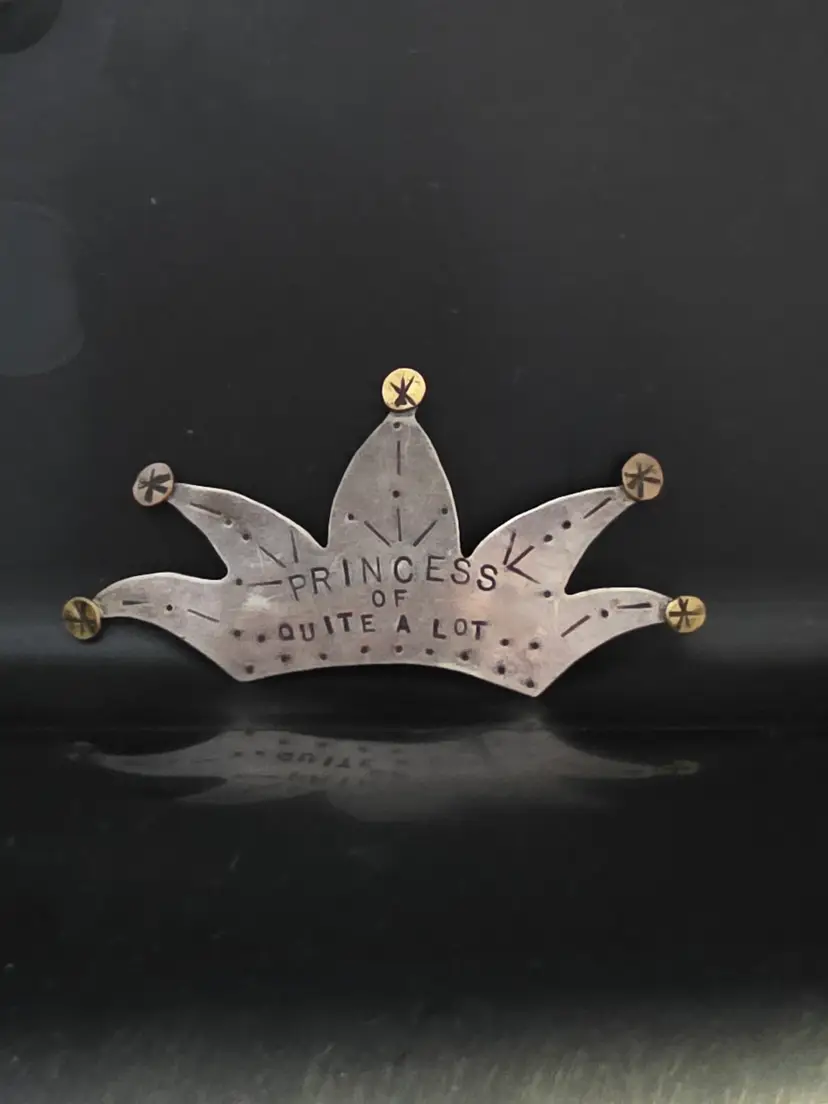 Hand Crafted Metal Crown Brooch with an Aged Silver-like Finish and Brass-toned Rivet Accents, Stamped with the Text PRINCESS OF QUITE A LOT