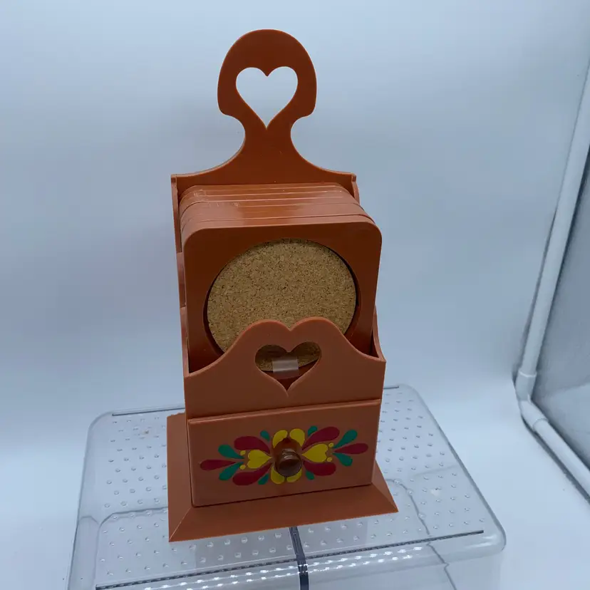 #1339 A vintage plastic coaster set with a hand-painted floral design.