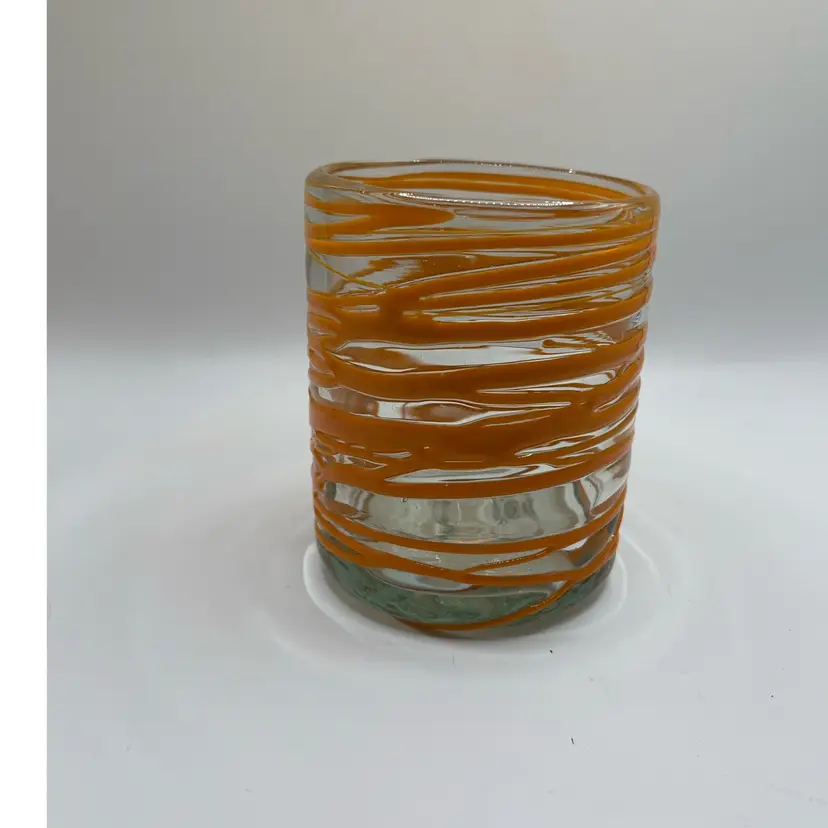 Verve Culture Mexican handblown glass featuring a vibrant orange swirl pattern.
