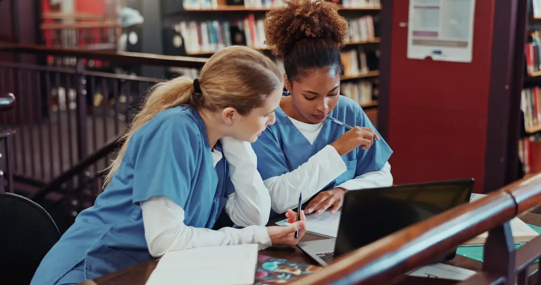Two pharmacy students studying together in a library