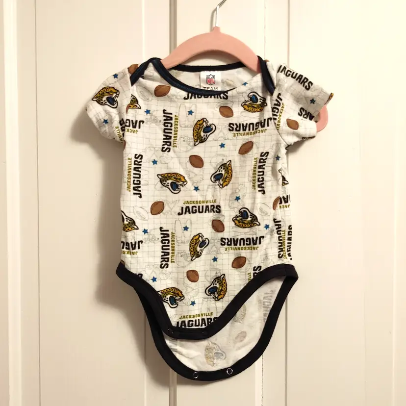 Kids- Brand: NFL. Size 3-6 months. Jacksonville Jaguars onesie. Material- 60% cotton, 40% polyester. No callouts.