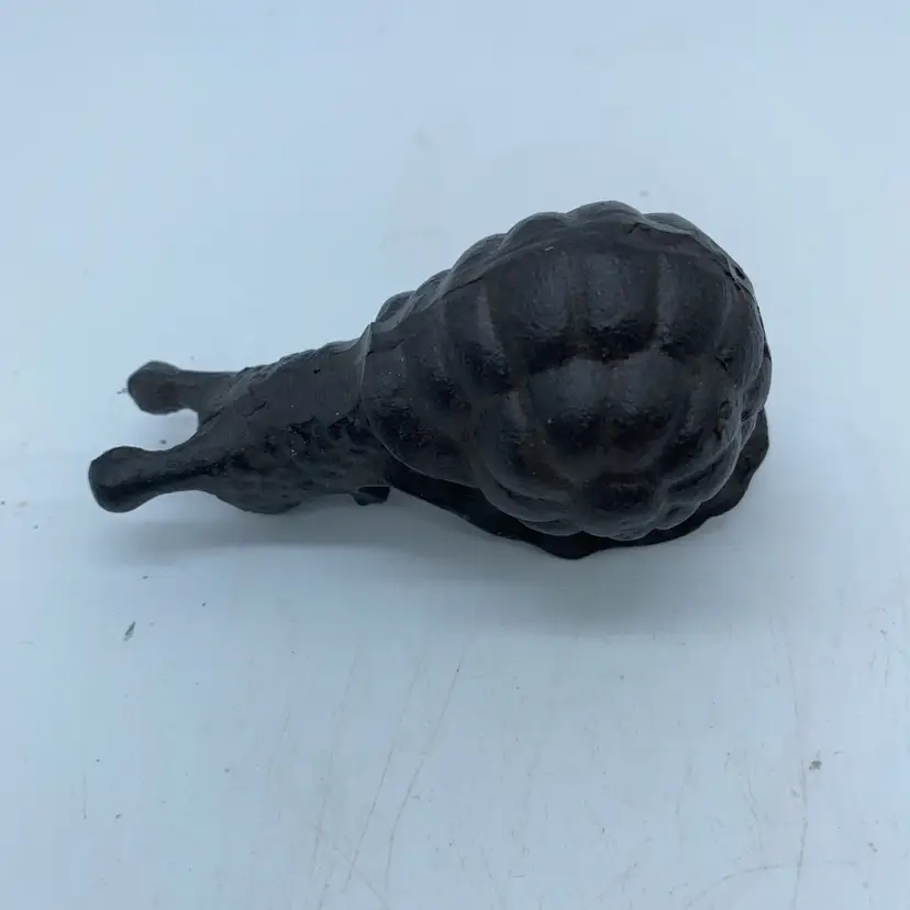 #1460 This is a cast iron snail-shaped pot hanger for decorative use.