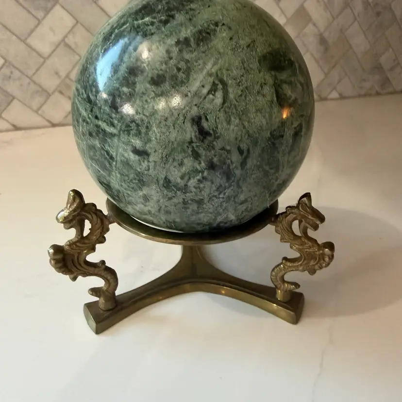 Vintage polished green marble sphere on a cast brass dragon stand.