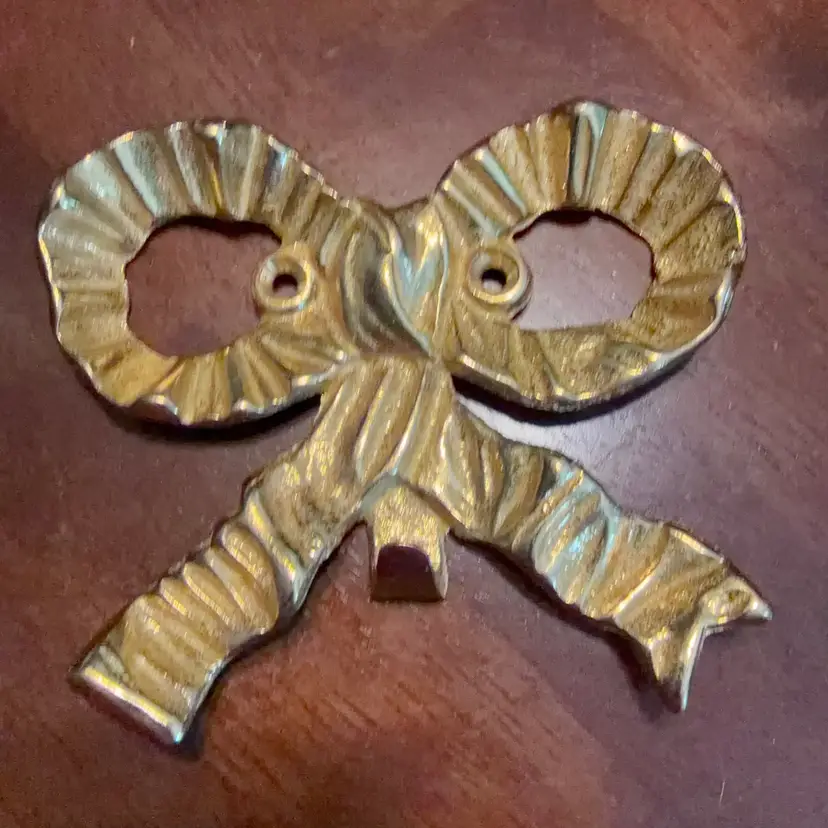 This is a vintage polished brass ribbon bow decorative wall hook. 1980-1990
