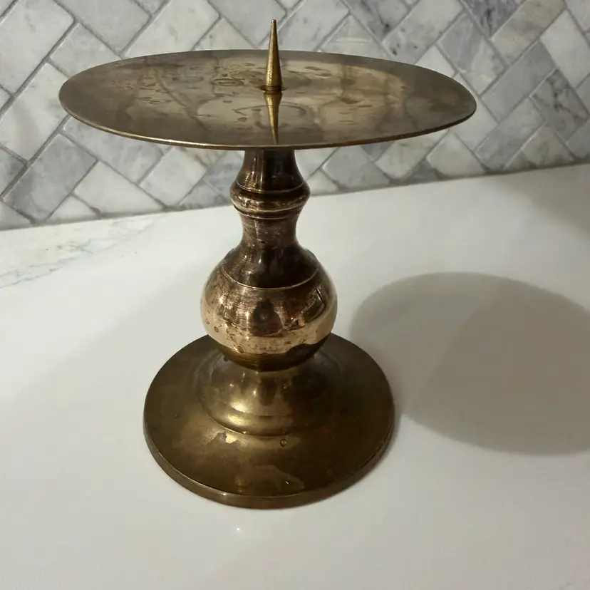 mid-to-late 20th-century cast brass pillar candle holder with a central spike.