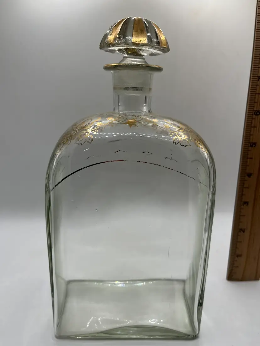 vintage Spanish clear glass liquor decanter featuring hand-painted gold grape and vine shoulder accents and a matching fluted gold-and-clear glass stopper.