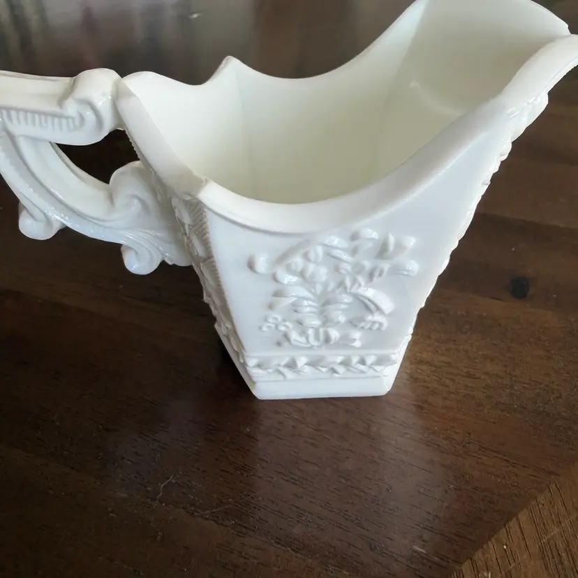A vintage white milk glass creamer with embossed floral design by Gullaskruf. Circa 1970