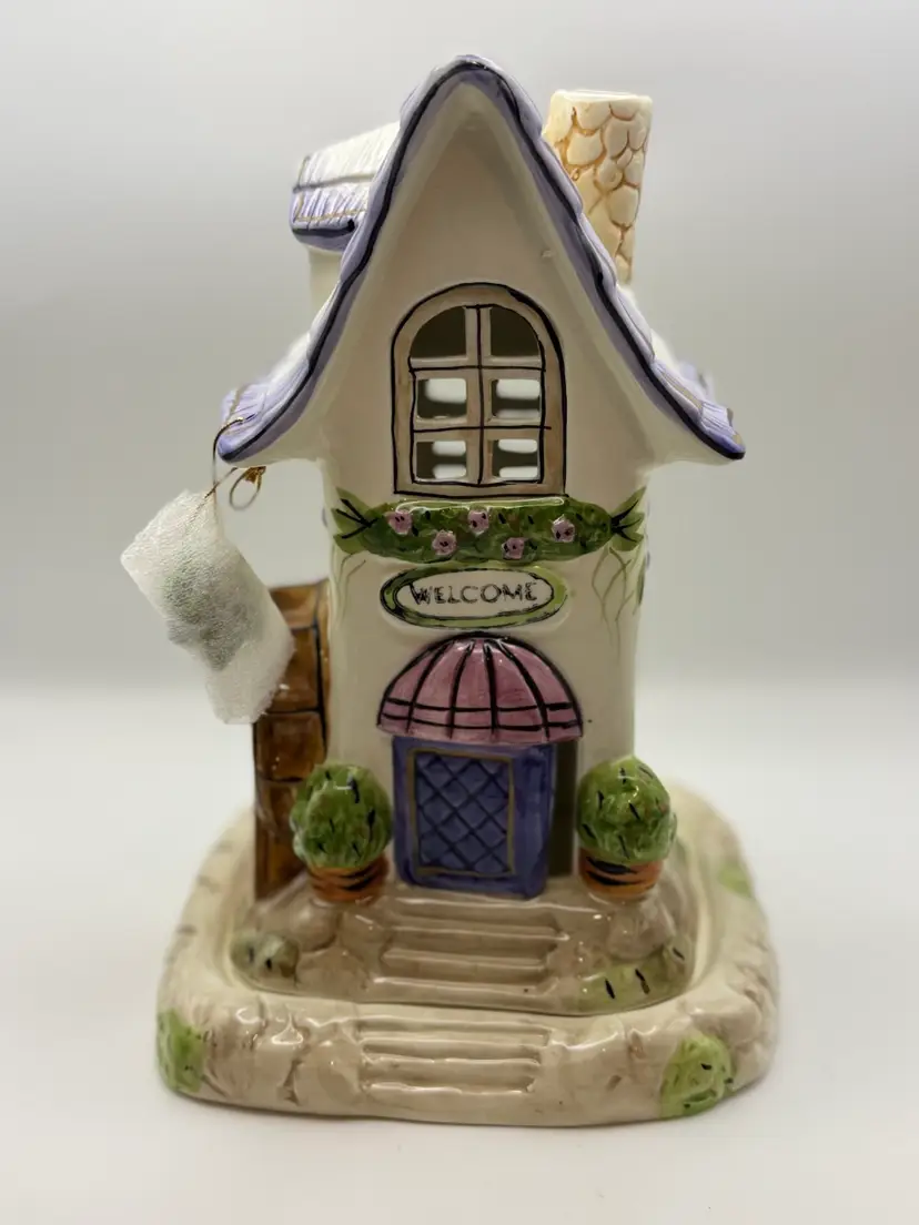 Hand painted ceramic tealight candle house featuring a "WELCOME" sign, made by the East West Distributing Co. (Item #850110). 9.5”