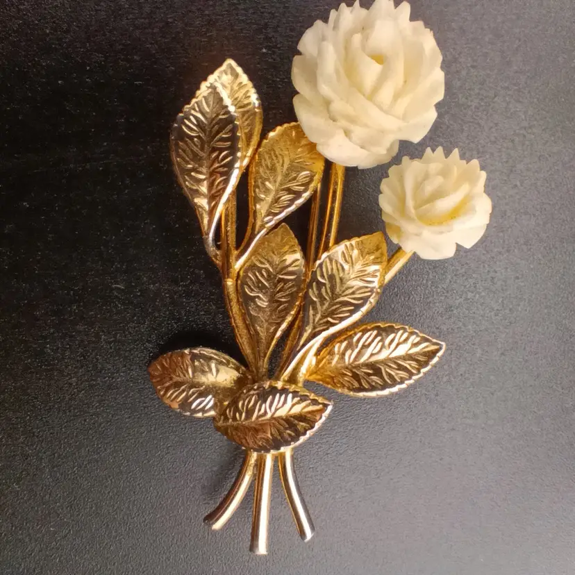 Gold tone and carved plastic flower brooch
