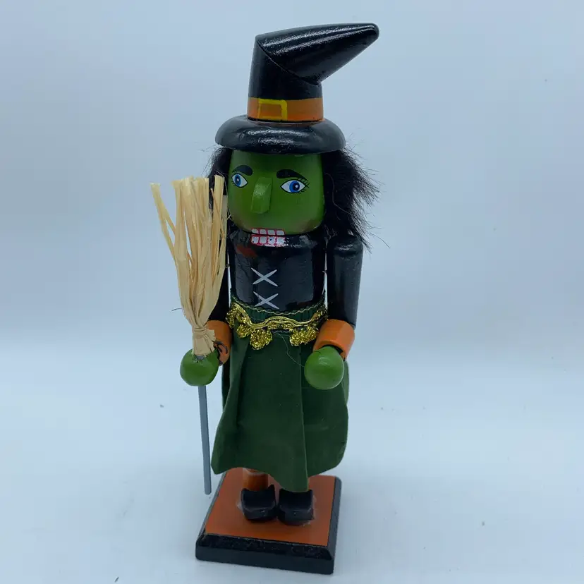 #4019 Wooden Halloween witch nutcracker holding a broom.