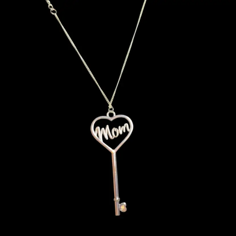31 Inch Silvertone Chain With A A Key That For A Pendant That Has Mom Written In The Middle And At The Bottom, It Has An Iridescent Bead