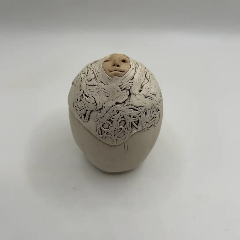 vintage studio art pottery lidded trinket box featuring a hand-sculpted face emerging from intricate “egg” flowing hair or abstract line work, created by artist Jude Holdsworth during the late 1980s. Delightfully Weird
