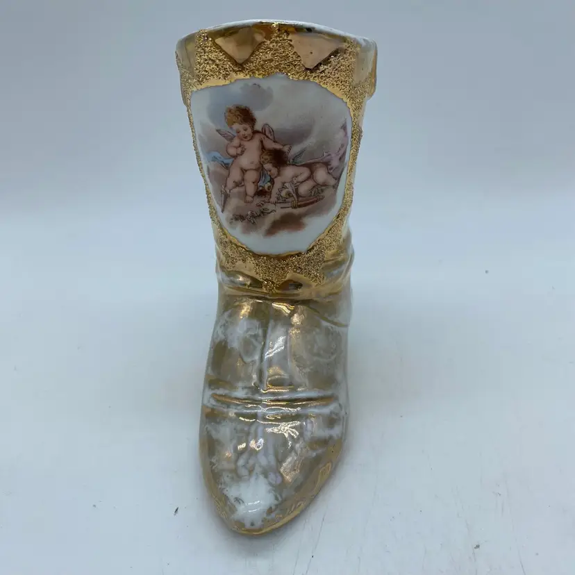 #1415 Vintage porcelain decorative boot figurine with cherub motif and gold accents (flaw).