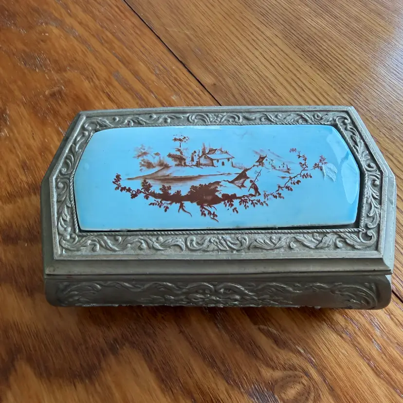 Antique enameled metal Jewelry box with landscape scene and ornate frame. 7”x4”x 2.5”