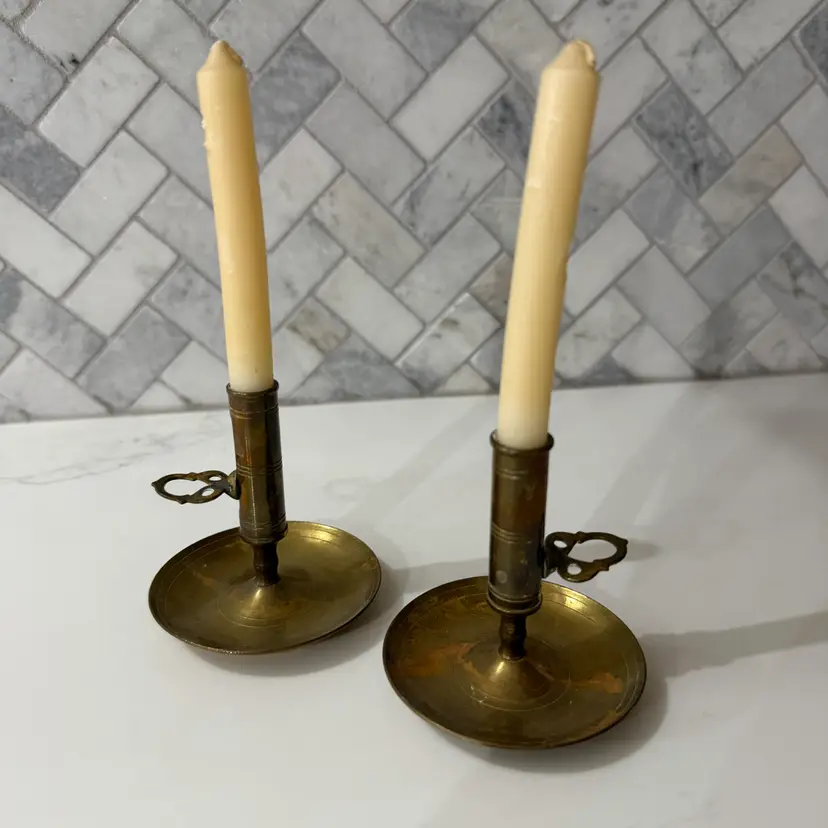 A pair of 19th-century antique brass push-up chamberstick candle holders.