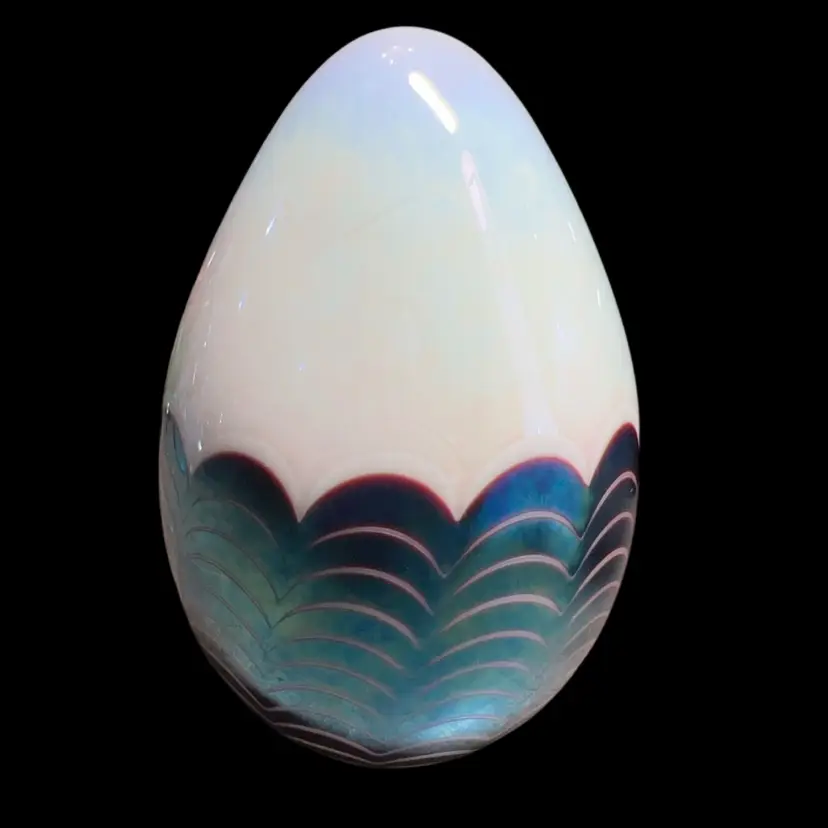 This paperweight is a Glass Eye Studio (GES) creation, handcrafted in Seattle, Washington.
The abbreviation "GES" stands for Glass Eye Studio, and the "93" denotes the year it was made, 1993. Pulled Feather Style. During this era, the studio frequently incorporated real volcanic ash from the 1980 eruption of Mount St. Helens into its iridescent glass pieces